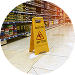 A yellow caution sign on the floor warns that the surface is wet and slippery.